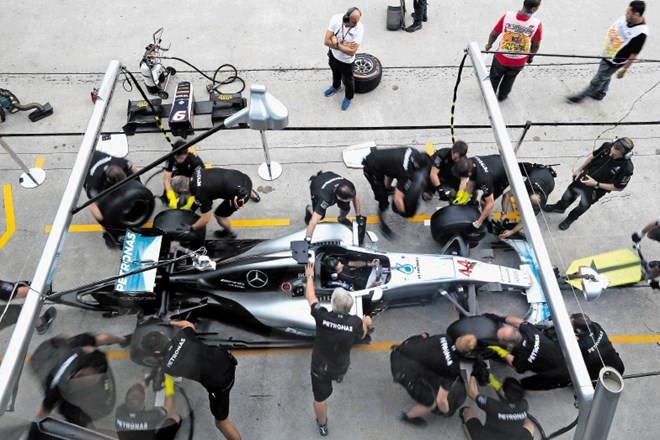 Pred dirko v Maleziji Mercedesovi mehaniki vadijo zamenjavo pnevmatik na bolidu Lewisa Hamiltona.