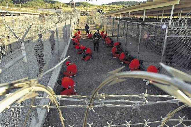 Na fotografiji iz  januarja 2002 je večina od prvih dvajsetih zapornikov, ki so jih pripeljali  v Guantanamo. Zaprli so jih v...