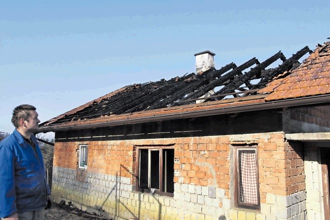 Roman Gračnar ob hiši v Marijini vasi, ki je po požaru v notranjosti povsem uničena.