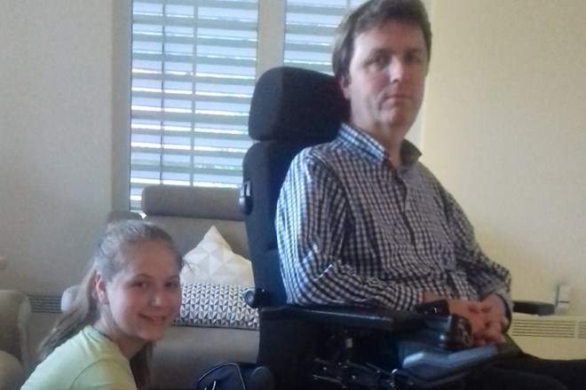 Sara Hrašar in njen očim Tone na invalidskem vozičku, zaščitenem s compatki.