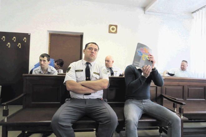 Janoš Gumpot (spredaj desno), ki mu je sodnica podaljšala pripor v zaporno kazen, je skril svoj obraz, Marjan Špegel (sedi...