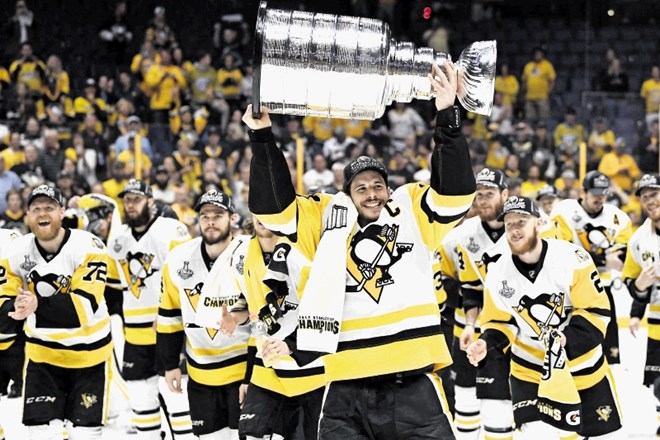 Kapetan Pittsburh Penguins Sidney Crosby je takole visoko v zrak dvignil Stanleyjev pokal.