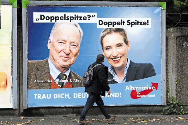 Moški hodi mimo predvolilnega plakata stranke Alternativa za Nemčijo, na katerem sta njena glavna kandidata na volitvah:...