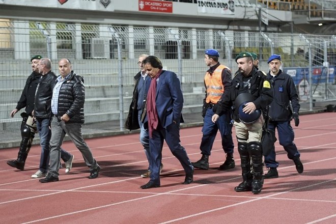 Predsednik nogometnega kluba Sion zapušča stadion v spremstvu policije. (Foto: AP)