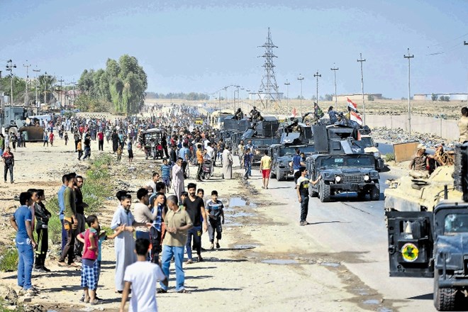 Ljudje ob cesti pozdravljajo iraško vojsko na poti proti Kirkuku. Vojska se je napotila na območja pod nadzorom Kurdov, potem...