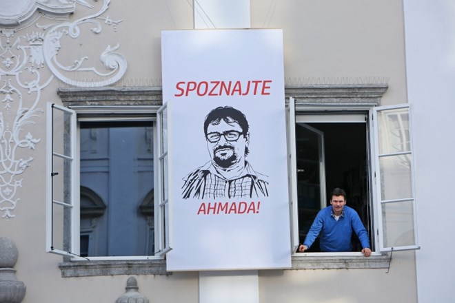 Izobešen plakat z obrazom sirskega begunca Ahmada na stavbi SAZU v Ljubljani.