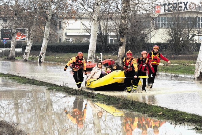 Gasilci med reševanjem ljudi, potem ko je reka Enza na severu Italije prestopila bregove in poplavila naseljena območja.