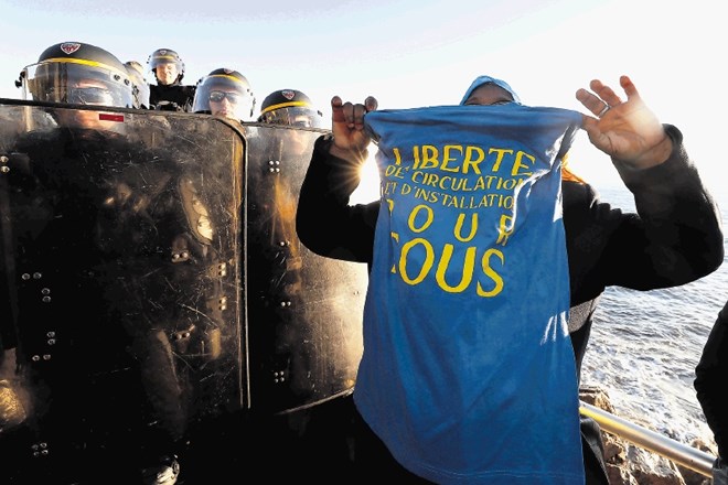 Migrant razobeša majico z napisom Svoboda gibanja med protesti migrantov v francoskem mestu Menton ob meji z Italijo.