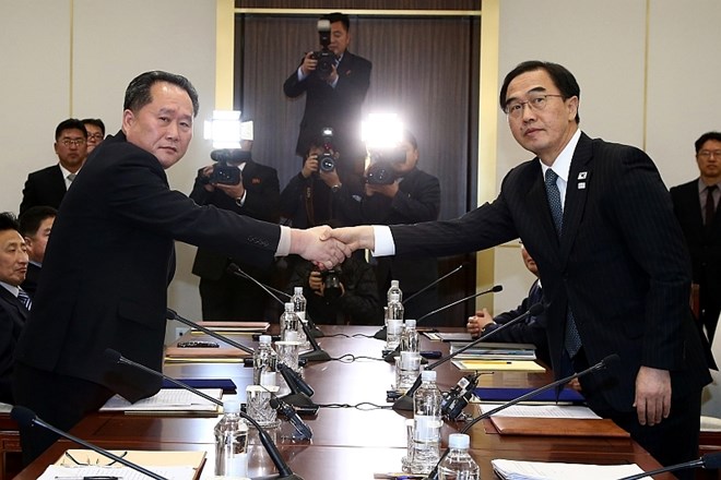 Južnokorejski minister za združitev Cho Myoung-gyon (desno) se rokuje z vodjo severnokorejske delegacije Ri Son Gwonom.