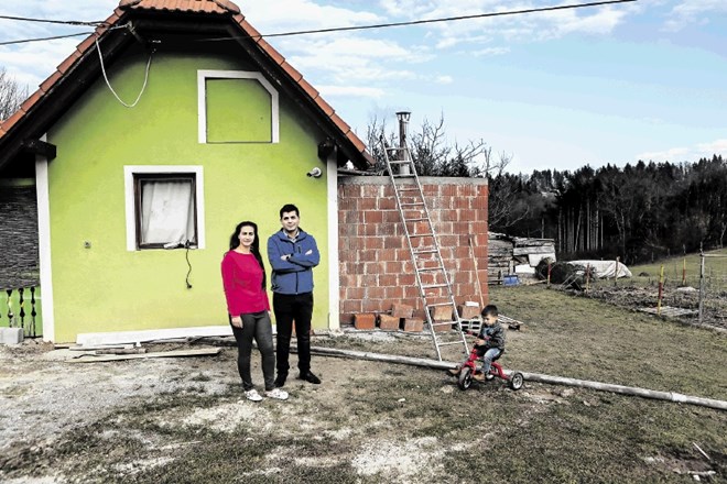Bogdan Miklič s soprogo in otrokom ob svoji hiši na Ruperč vrhu. »Hiša stoji na občinski zemlji, kopalnico pa sem dozidal na...