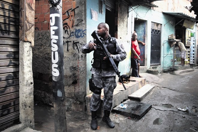 Brazilski vojak patruljira po ulicah favele Kelson v Riu de Janeiru.