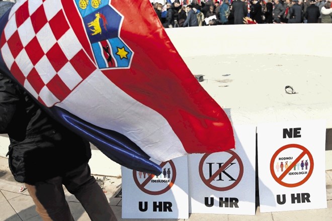 Moški s hrvaško zastavo pred plakati proti carigrajski  konvenciji in ideologiji spolov