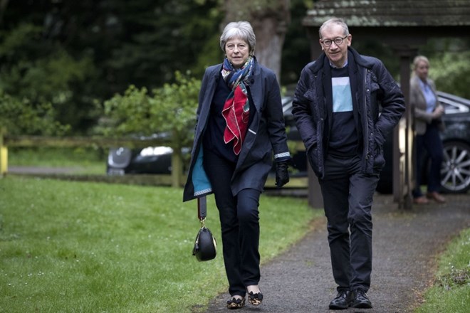 Britanska premierka Theresa May z možem Philipom na poti v cerkev.