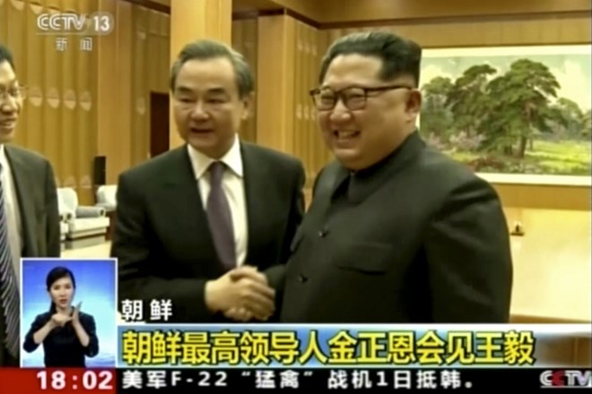 Wang Yi na levi in Kim Jong Un na desni.