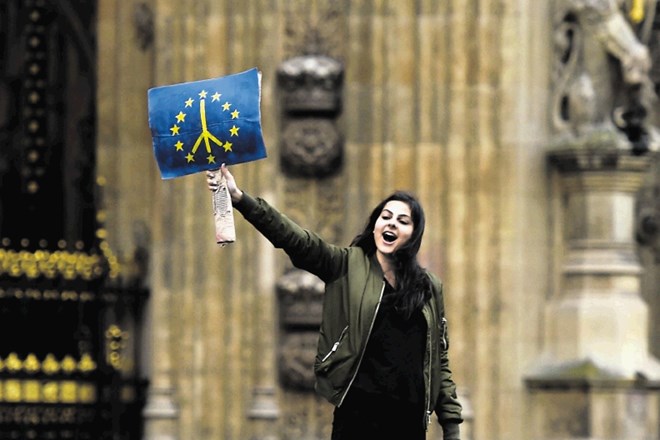 Zagovornica britanskega članstva v Evropski uniji maha z modro zastavo pred poslopjem poslanske zbornice v središču Londona.