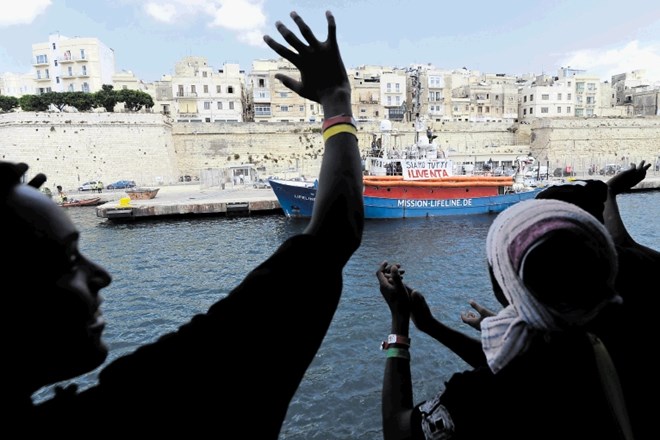 Migranti na ladji Aquarius mahajo in se veselijo, da so jim končno dovolili izkrcanje na Malti.