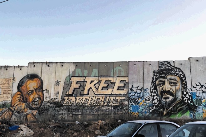Ponekod so Palestinci zid poslikali z obrazi političnih voditeljev. Na tem v Kalandiji, ki ločuje območji Ramale in...