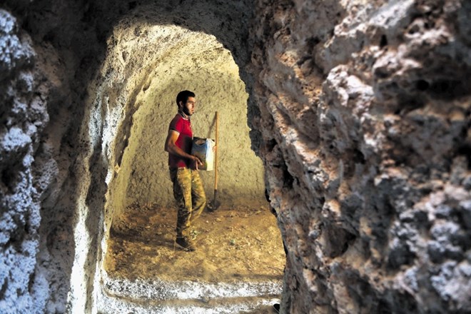 Petindvajsetletni Ali Bakor v vasi Mar Šurin v sirskem Idlibu odnaša material iz podzemnega bivališča, ki ga je skupaj z...