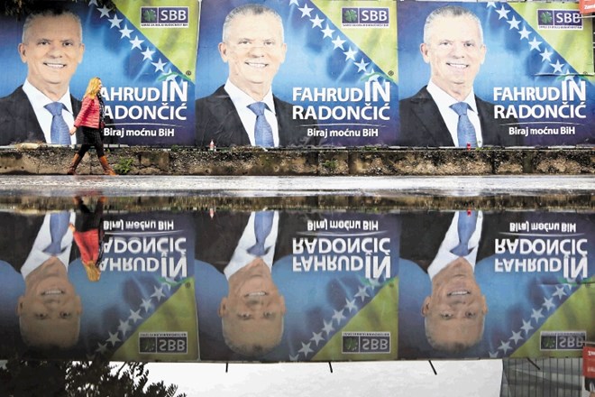 Sarajevčanka hodi mimo plakatov, na katerih se volilcem ponuja kandidat za bošnjaškega člana predsedstva Fahrudin Radončić iz...