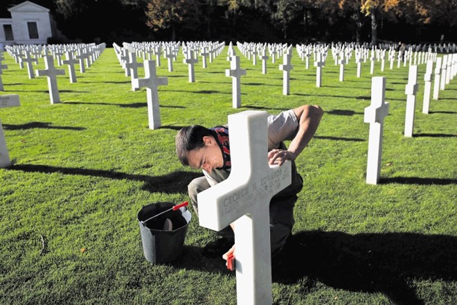 Zaposleni na pokopališču na obrobju Pariza čisti križe na grobovih vojakov, padlih v prvi svetovni vojni, pred jutrišnjimi...