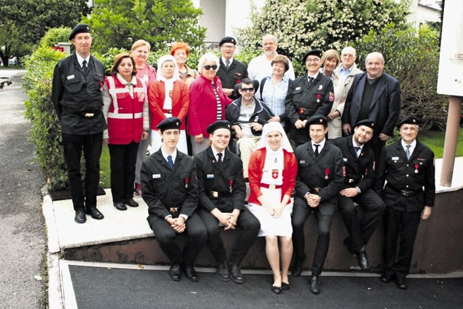 Alenka Ermenc (tretja z leve v srednji vrsti) nosi uniformo z emblemom  malteškega viteškega reda le kot prostovoljka,...
