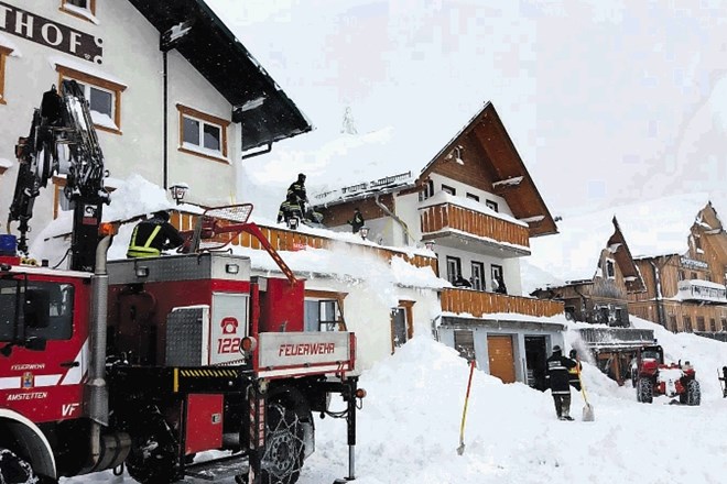 Gasilci in vojaki se takole spopadajo s snegom popolnoma prekrito vasjo ob sicer zaprti alpski cesti med Spodnjo Avstrijo in...