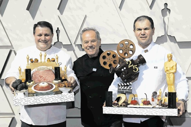 Kuharski mojster Wolfgang Puck (na sredini) z glavnimi zvezdami pooskarjevske večerje, od pozlačenih čokoladnih kipcev do...
