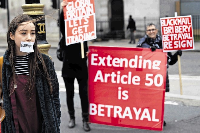 Zagovorniki britanskega izstopa iz EU protestirajo proti možnosti preložitve datuma brexita. »Prevara,« piše na lističu na...