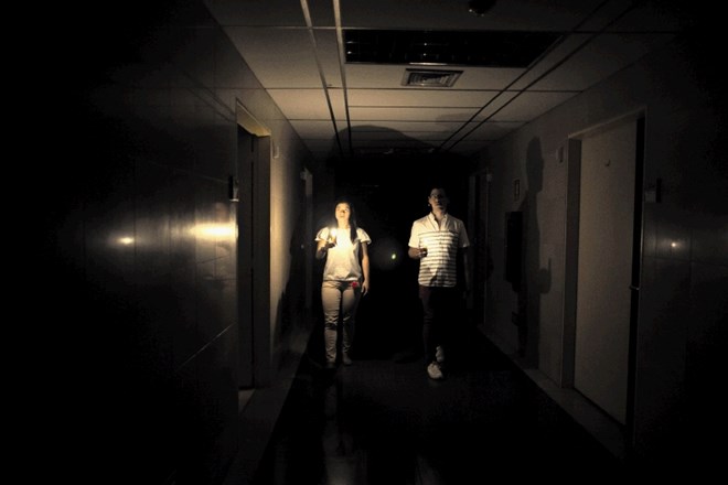 Sorodnika pacienta si s svečami osvetljujeta pot na hodniku bolnišnice v Caracasu med izpadom električne energije, ki je bil...