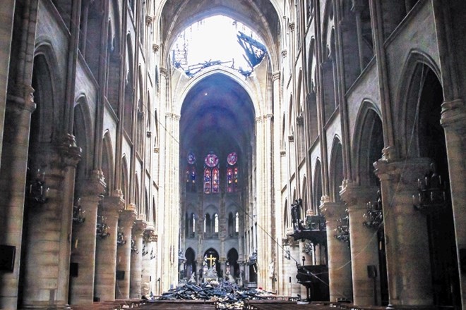 Luknja zeva pri kupoli notredamske katedrale, na tleh pa je viden material, ki je prav tja, kjer je oltar, padal med...