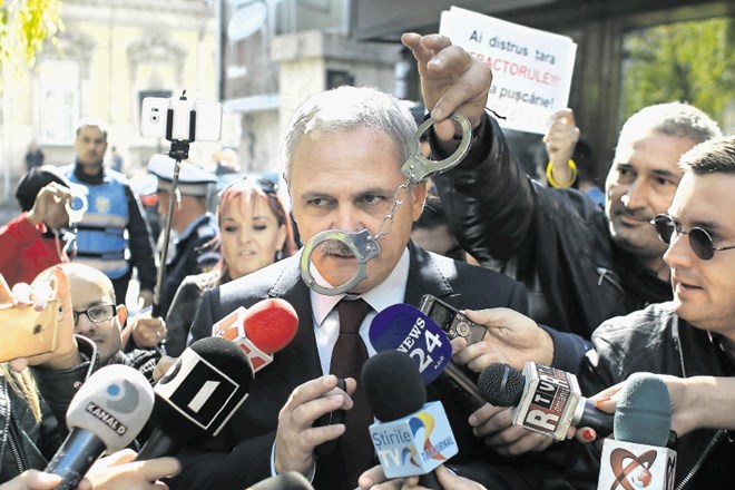 Protestnik na arhivski fotografiji maha z lisicami pred nosom vodje socialdemokratov Liviuja Dragnee. Zdaj so mu jih zares...