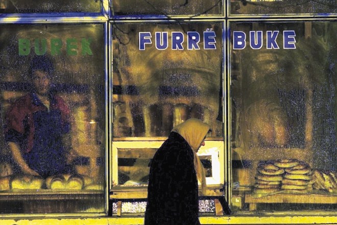 Ženska hodi mimo pekarne na arhivski fotografiji iz Kosovske Mitrovice. Trgovine, lokali, pekarne in drugi obrati na severu...