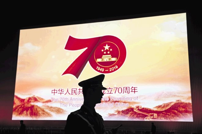 Silhueta kitajskega uniformiranca pred panojem ob 70. obletnici razglasitve ljudske republike.