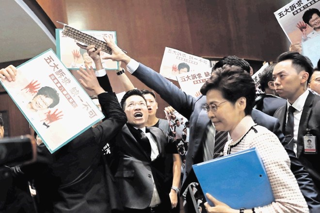 Voditeljico Hongkonga so ob prihodu v parlament opozicijski poslanci pričakali s plakati, na katerih je prikazana  z...