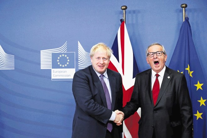 Vendarle močan stisk rok: britanski premier Johnson (levo) in predsednik evropske komisije Juncker po doseženem dogovoru o...