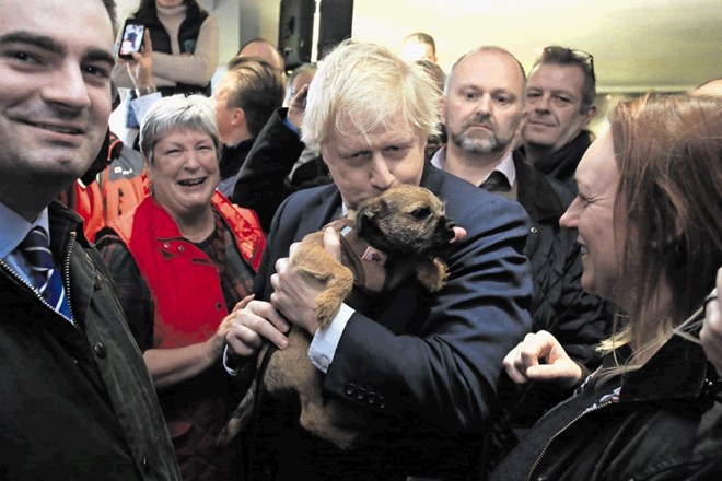Boris Johnson nadaljuje s svojimi populističnimi prijemi tudi po volitvah, kot je denimo poljubljanje kužka med obiskom...