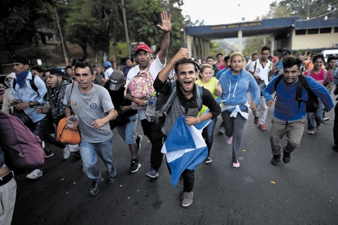 Migranti iz Hondurasa tečejo in pozdravljajo preboj blokade, ki jim jo je postavila policija na meji med Hondurasom in...