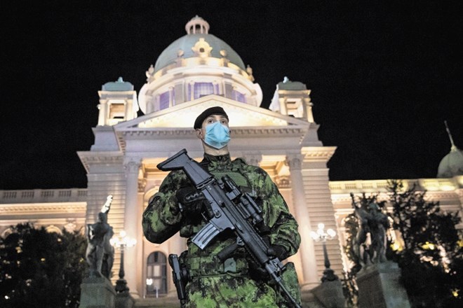 Vojak straži pred parlamentom v Beogradu v času policijske ure.