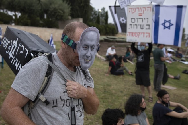 Moški z masko izraelskega premierja Benjamina Netanjahuja med protestom pred knesetom.
