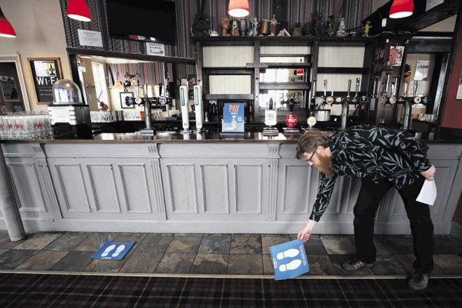 Are Kjetil Kolltveit, lastnik puba Chandos Arms v Londonu, je včeraj pred odprtjem puba tla pred točilnim pultom opremljal z...