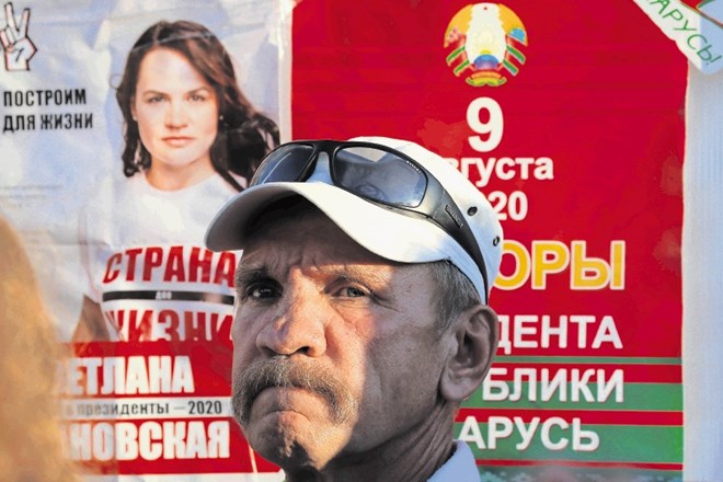 Moški stoji ob predvolilnem plakatu Svetlane Tihanovske, ki je dobila precejšnjo podporo Belorusov, a redkokdo verjame, da...