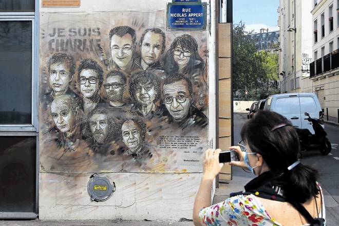 Ženska fotografira sliko francoskega uličnega umetnika Christiana Guemyja, znanega pod vzdevkom C215, ki jo je ustvaril v...