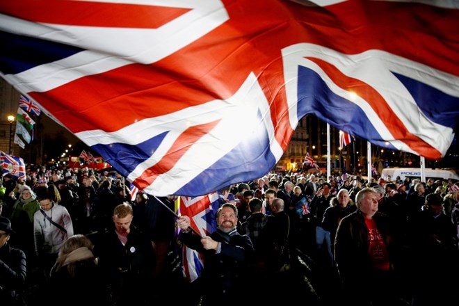 FILE PHOTO: A man waves a British flag on Brexit day in London, Britain January 31, 2020. REUTERS/Henry Nicholls/File Photo...