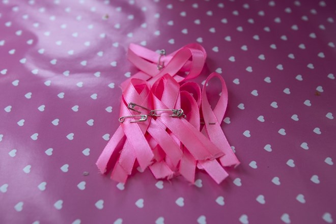 Simbolična fotografija - rožnata pentlja - simbol boja poti raku dojk