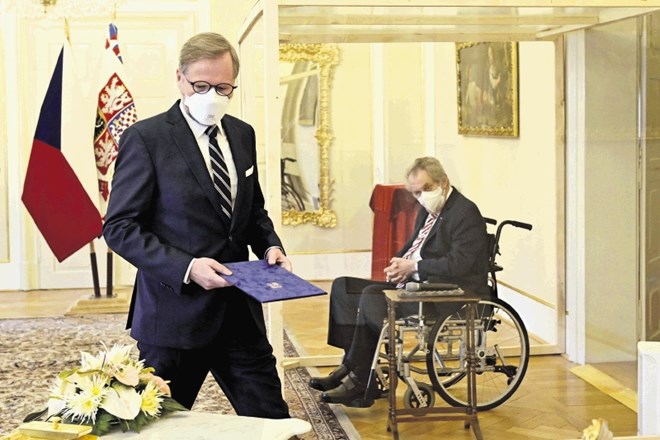 Češki predsednik Zeman (zadaj) je Petra Fialo za premierja imenoval v izolirani stekleni kocki zaradi okužbe z novim...