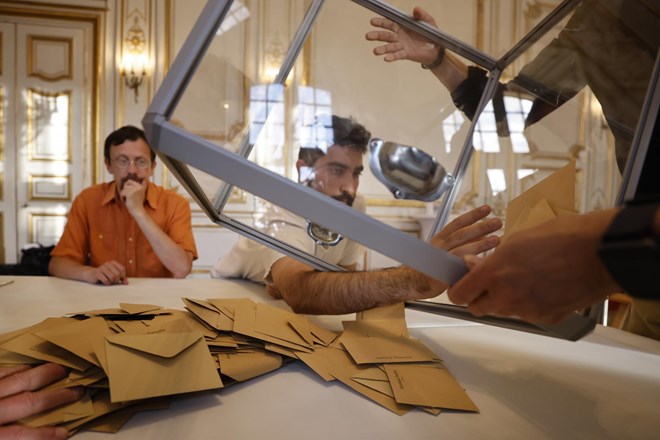 Macron v prvem krogu francoskih parlamentarnih volitev tesno pred Melenchonom
