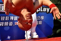 Kitajski kaskader se preživlja z dobro glavo na ramenih in stojo na žeblju