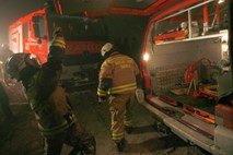 V nočnem požaru v Postojni poškodovani trije stanovalci, gasilec in živali