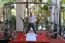 Vladimir Putin in Dimitrij Medvedjev v telovadnici napenjata bicepse 