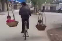 Spreten kitajski oče prevaža sinova na kolesu v košarah, obešenih na ramenih 